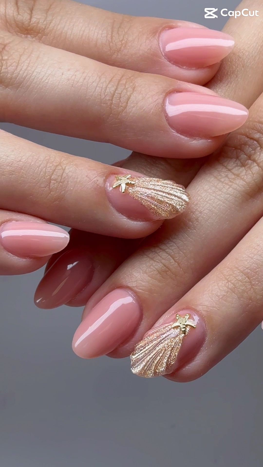 Soft pink manicure with gold shell accents, done at Victoria's